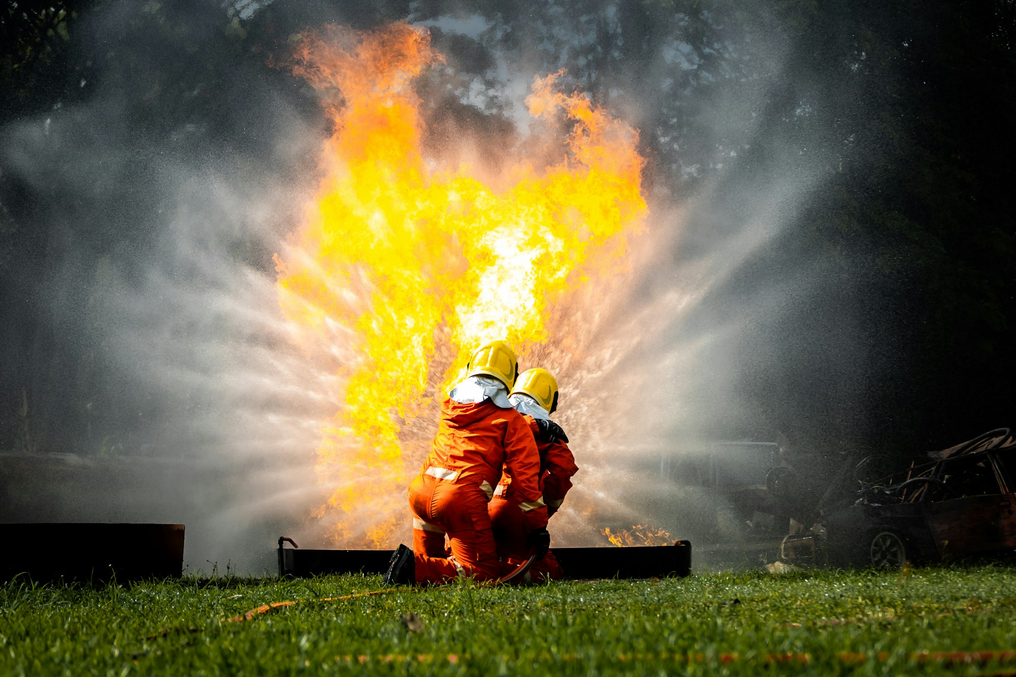 Firefighter Concept. Fireman using water and extinguisher to fighting with fire flame.